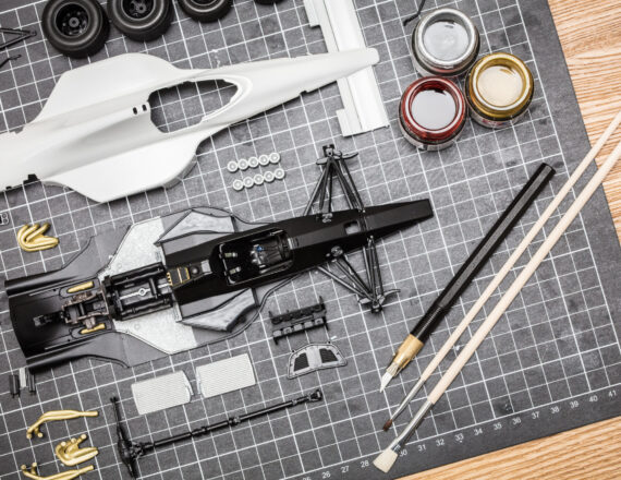 Toy Model Car Parts On A Desk A plastic model toy car kit being built in a home envornment